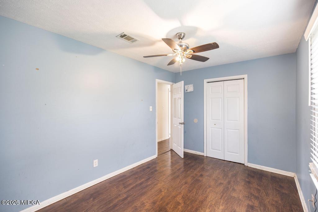 112 Prairie Boulevard Centerville, GA 31028 - Photo 24 of 32 a view of an empty room with chandelier fan and wooden floor