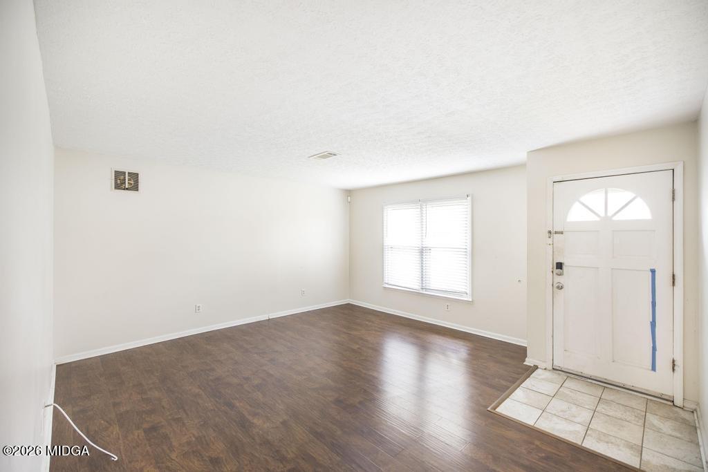 112 Prairie Boulevard Centerville, GA 31028 - Photo 7 of 32 an empty room with wooden floor and windows