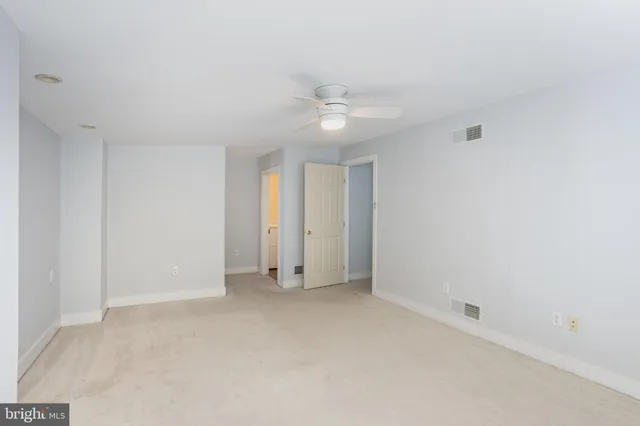 an empty room with a ceiling fan and a fan