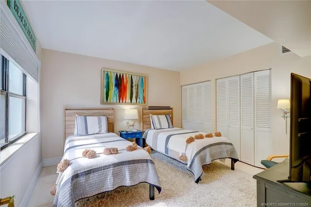 a bedroom with two beds and a window