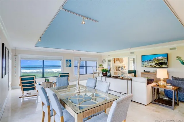 a living room with furniture a large window and kitchen view