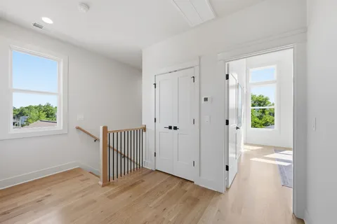 a view of a hallway with wooden floor and a window