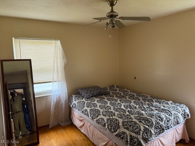 15513 Rockside Road Maple Heights, OH 44137 - Photo 2 of 11 Bedroom with wood finished floors, a textured ceiling, and ceiling fan