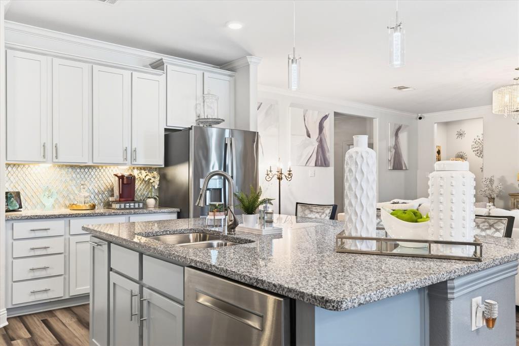 2816 Permian Road Aubrey, TX 76227 - Photo 14 of 36 Kitchen featuring stainless steel appliances, ornamental molding, light stone countertops, a chandelier, and dark wood-type flooring