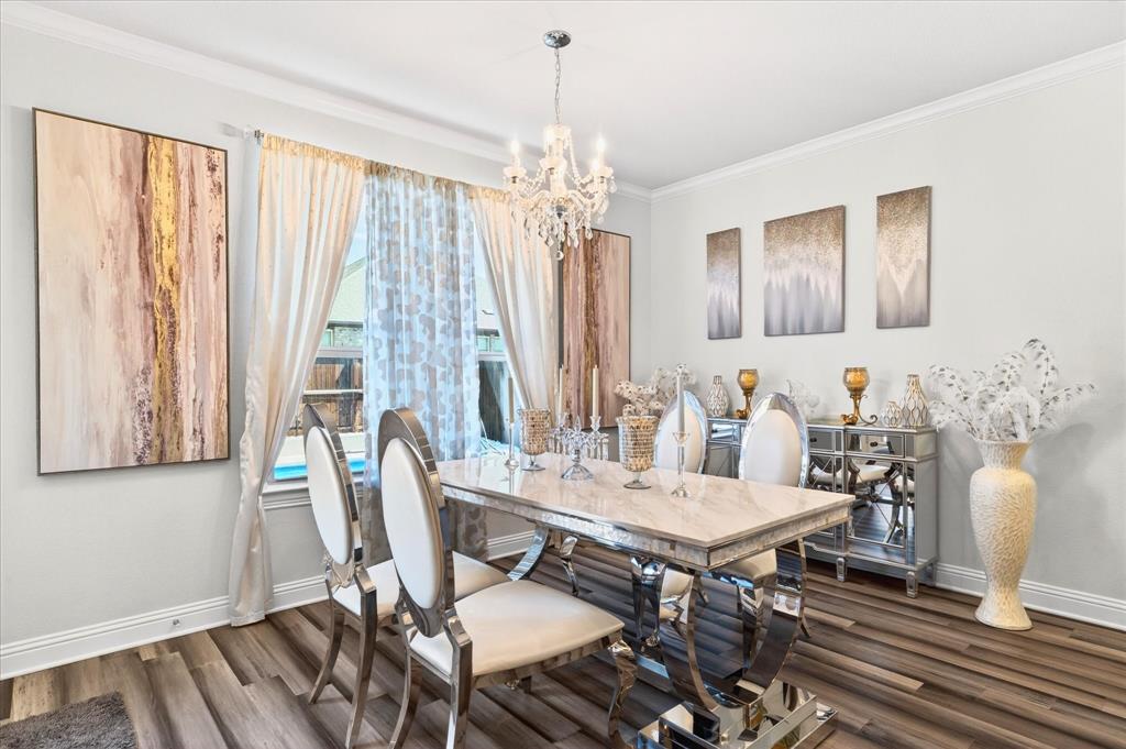 2816 Permian Road Aubrey, TX 76227 - Photo 15 of 36 Dining area featuring suspended lighting, crown molding, and dark wood-style floors