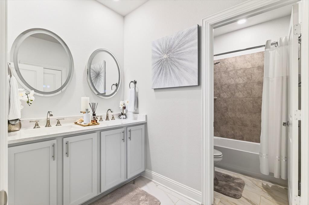 2816 Permian Road Aubrey, TX 76227 - Photo 19 of 36 Full bath featuring double vanity, shower / bath combo, and light marble finish flooring