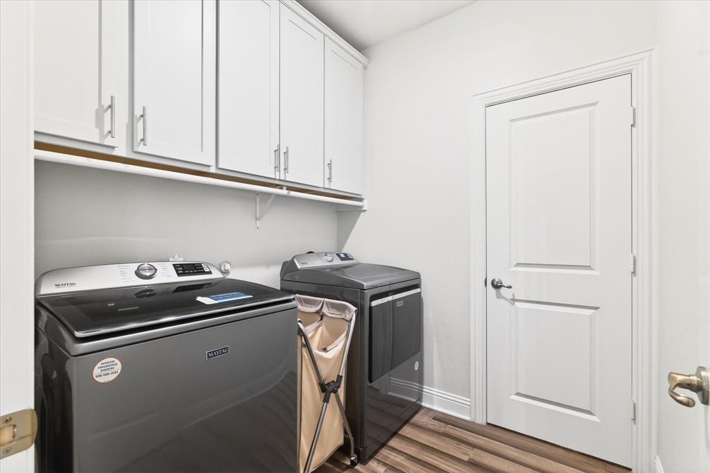 2816 Permian Road Aubrey, TX 76227 - Photo 25 of 36 Laundry room featuring dark wood finished floors, cabinet space, and washing machine and clothes dryer