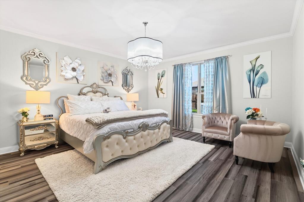 2816 Permian Road Aubrey, TX 76227 - Photo 5 of 36 Bedroom with ornamental molding, dark wood-style floors, and suspended lighting