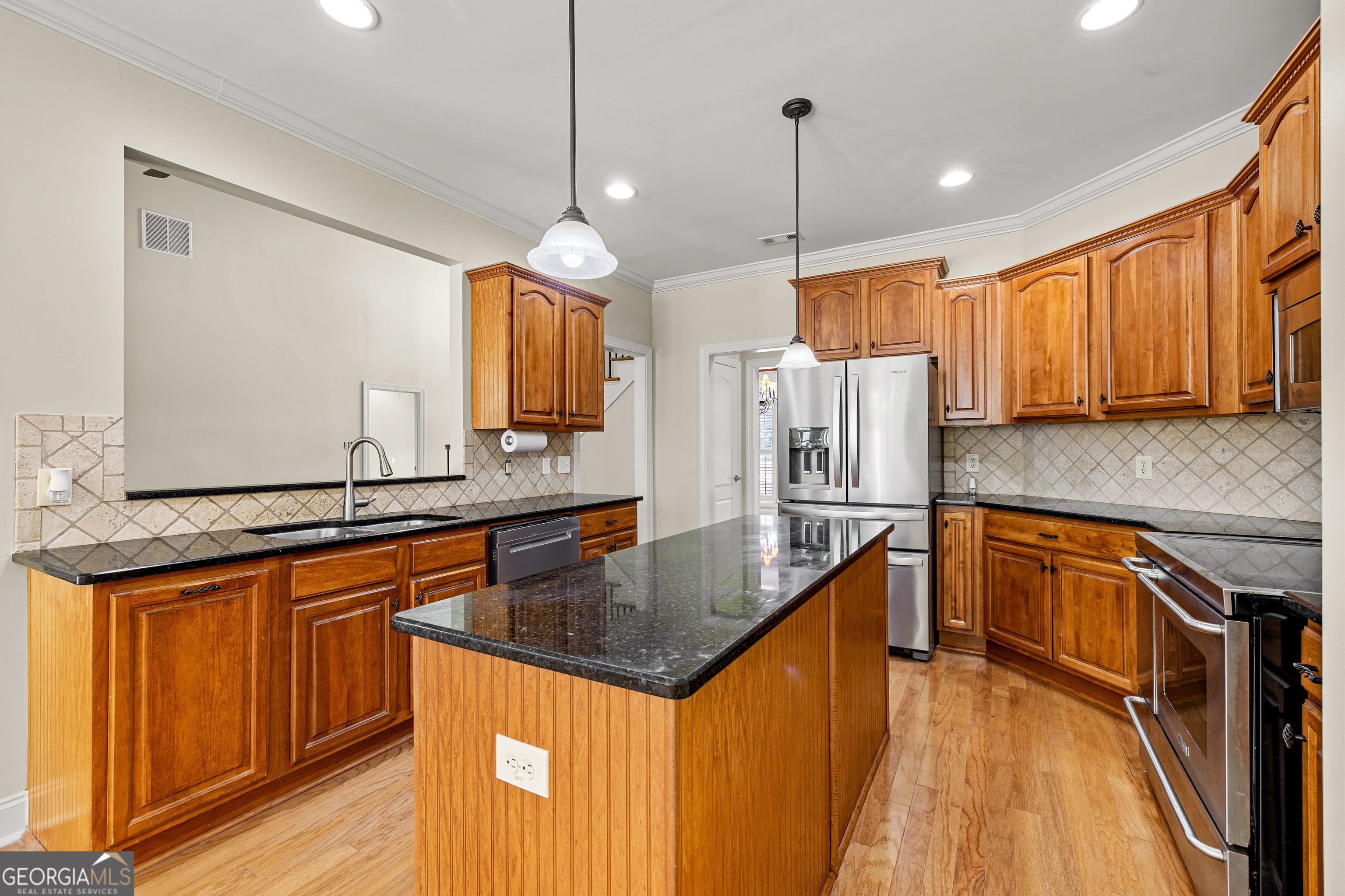 120 Shankhill Ridge Tyrone, GA 30290 - Photo 21 of 53 a kitchen with stainless steel appliances granite countertop a sink a stove and a wooden floors