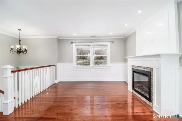 a view of empty room with wooden floor and fireplace