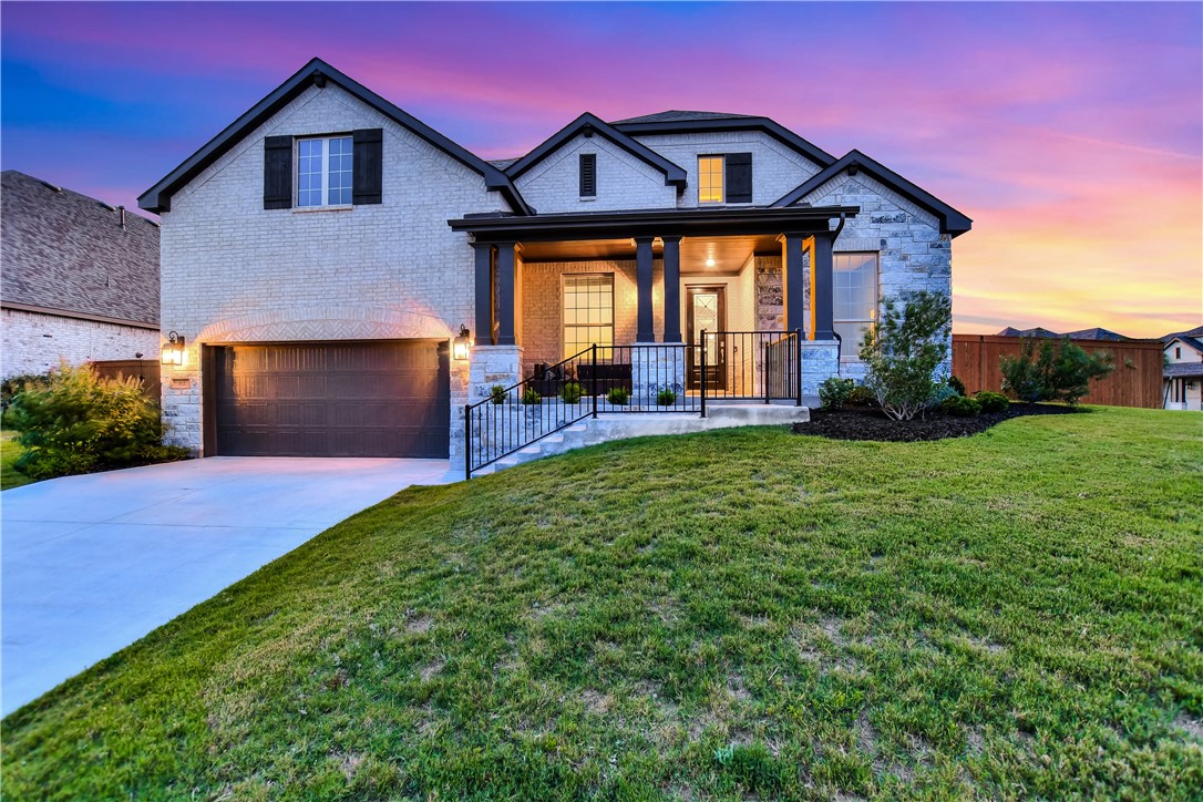 a front view of a house with a yard and garage