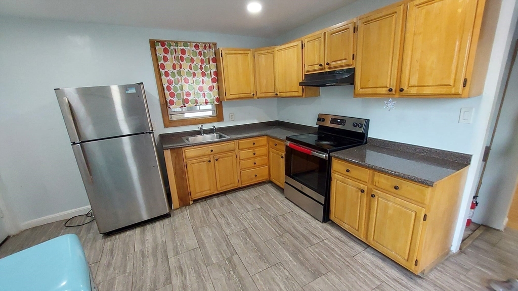 124 Marcella Street, Unit 1 Boston, MA 02119 - Photo 4 of 13 a kitchen with stainless steel appliances granite countertop a refrigerator a stove a sink and a microwave