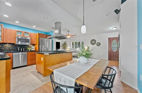 a kitchen with stainless steel appliances kitchen island granite countertop a table and chairs in it