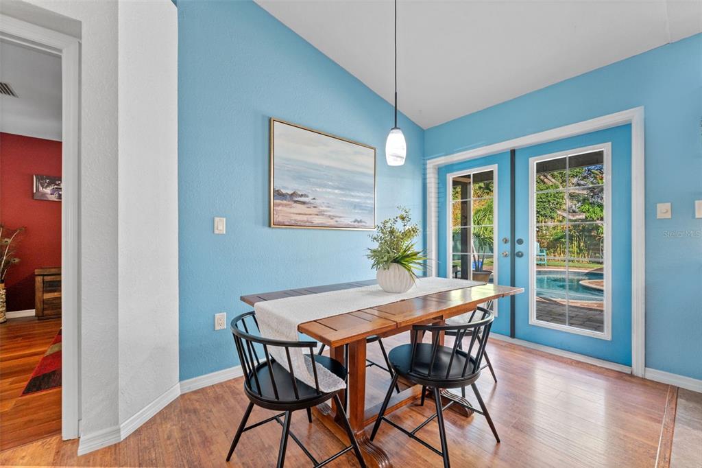 1441 Santa Anna Drive Dunedin, FL 34698 - Photo 12 of 34 a view of a dining room with furniture wooden floor and chandelier