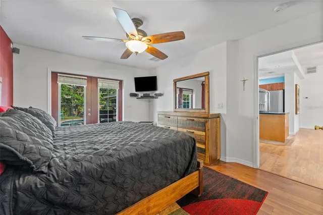 a bedroom with a bed dresser and a large window