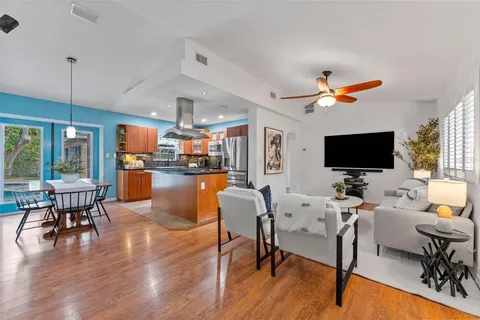 a living room with furniture kitchen view and a large window