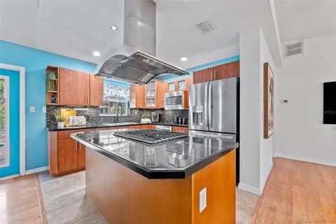 a kitchen with stainless steel appliances granite countertop a sink a stove and a refrigerator