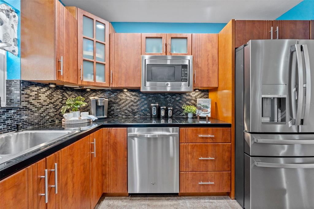 1441 Santa Anna Drive Dunedin, FL 34698 - Photo 10 of 34 a kitchen with stainless steel appliances granite countertop a refrigerator and a sink