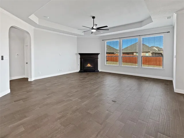 an empty room with large windows and fireplace
