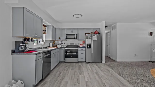 a kitchen with a refrigerator a stove and a sink