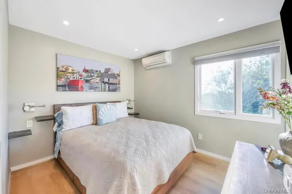 a bedroom with a bed and a painting on the wall