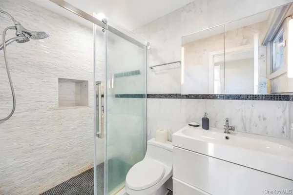 a bathroom with a sink a toilet and shower