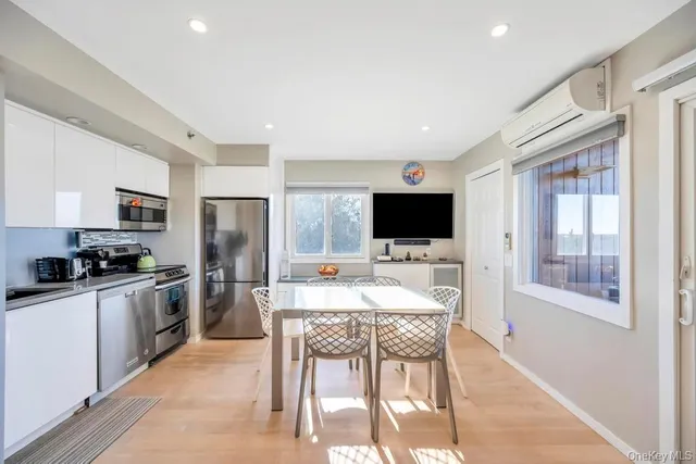 a kitchen with stainless steel appliances a stove top oven a sink a dining table and chairs