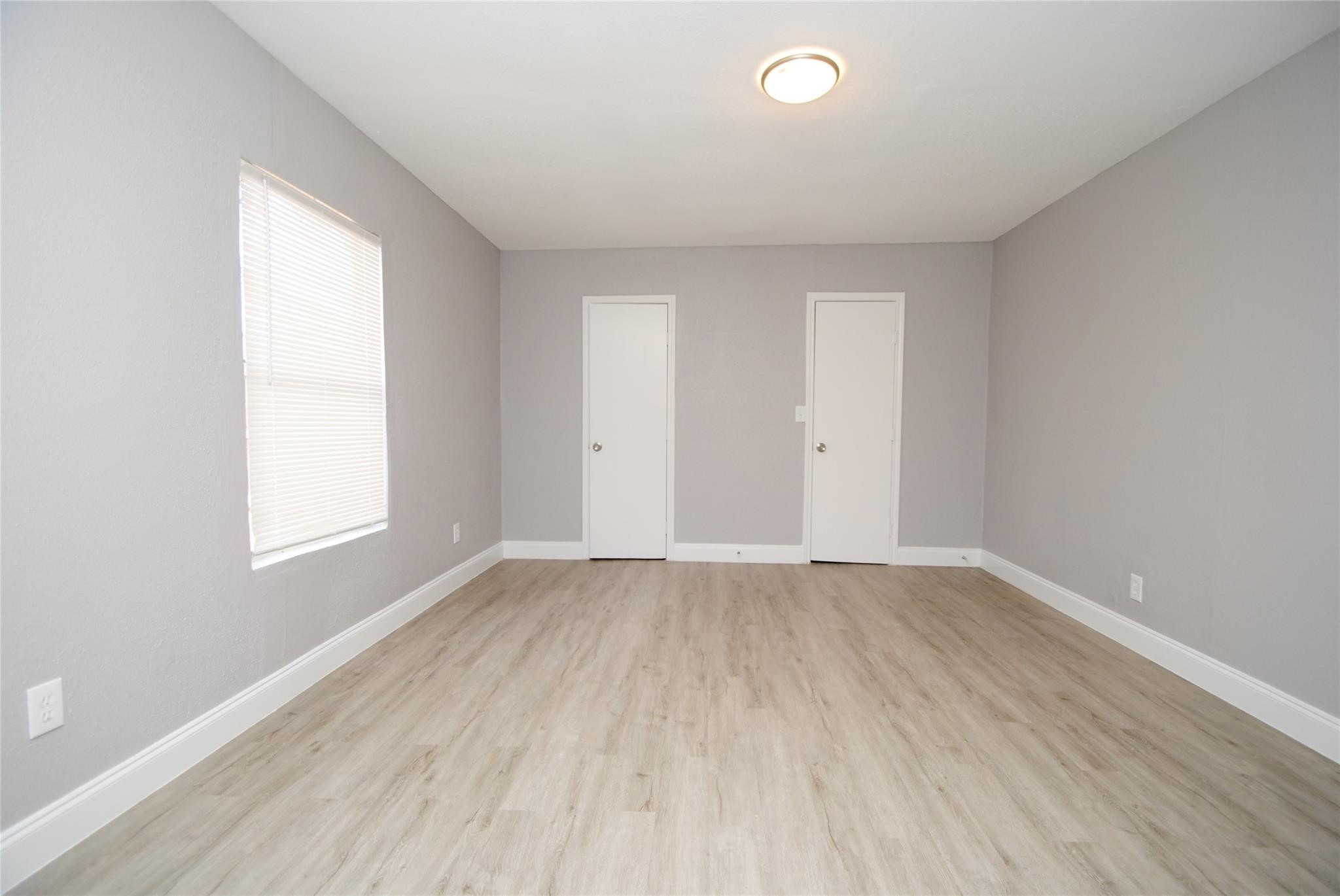 12802 Newbrook Drive Houston, TX 77072 - Photo 13 of 17 an empty room with wooden floor and windows