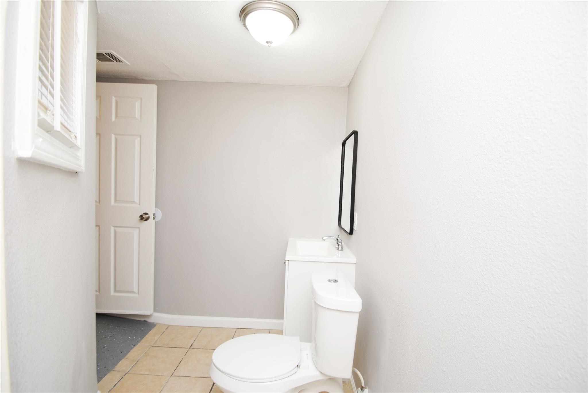 12802 Newbrook Drive Houston, TX 77072 - Photo 14 of 17 a white toilet sitting next to a bathroom sink
