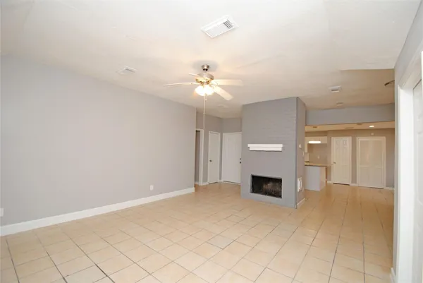 an empty room with fireplace and windows