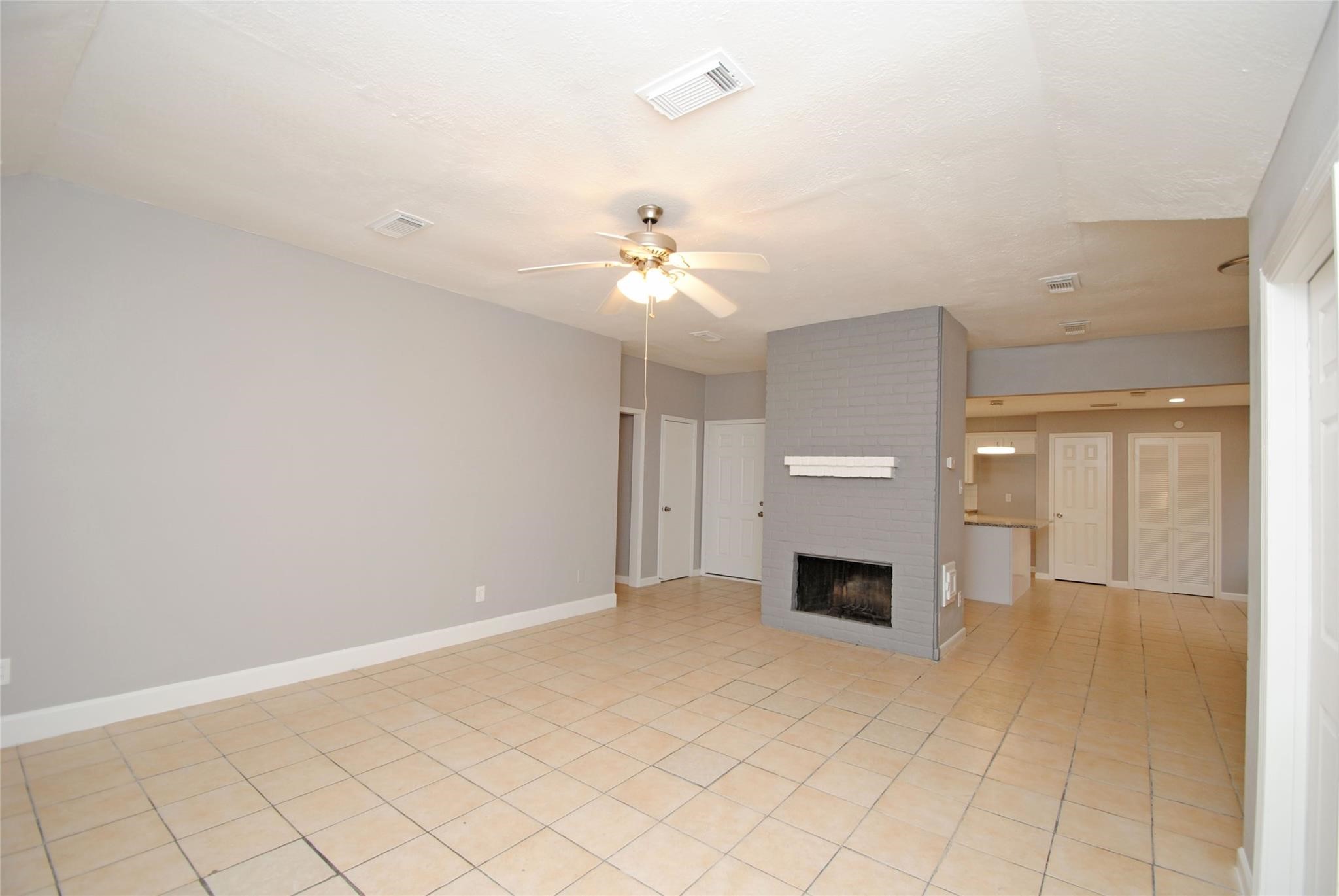 12802 Newbrook Drive Houston, TX 77072 - Photo 3 of 17 an empty room with fireplace and windows