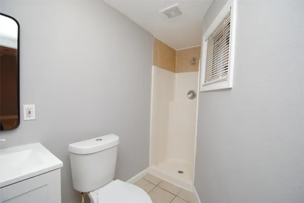 a view of an empty room with window and a bathroom