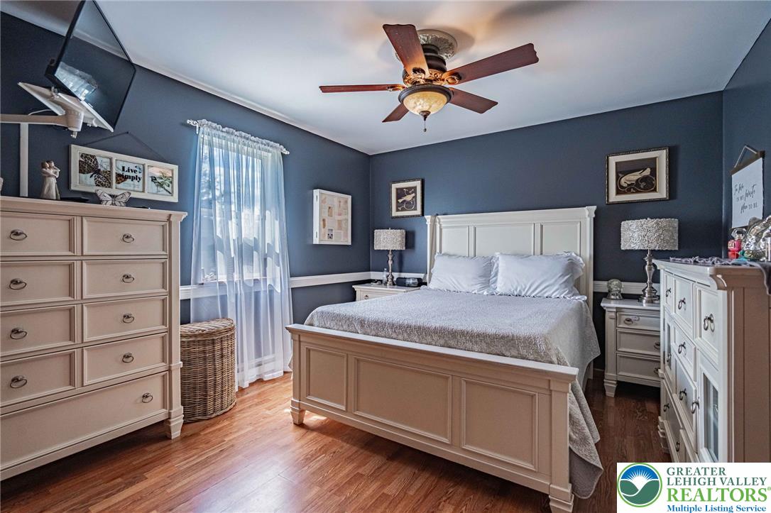 341 Lower Greenhill Road Kunkletown, PA 18058 - Photo 19 of 69 Wood flooring flows through this comfortable bedroom, featuring a classic ceiling fan and ample natural light.
