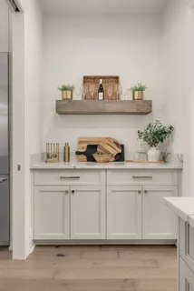 a white kitchen with a sink and wooden floor