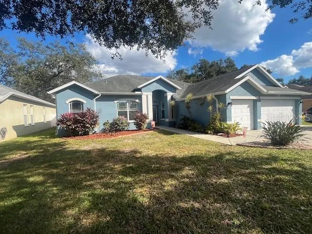 a front view of a house with a garden and trees