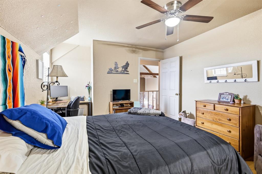 309 Sanders Road Denton, TX 76210 - Photo 18 of 40 a bedroom with a bed and a chandelier