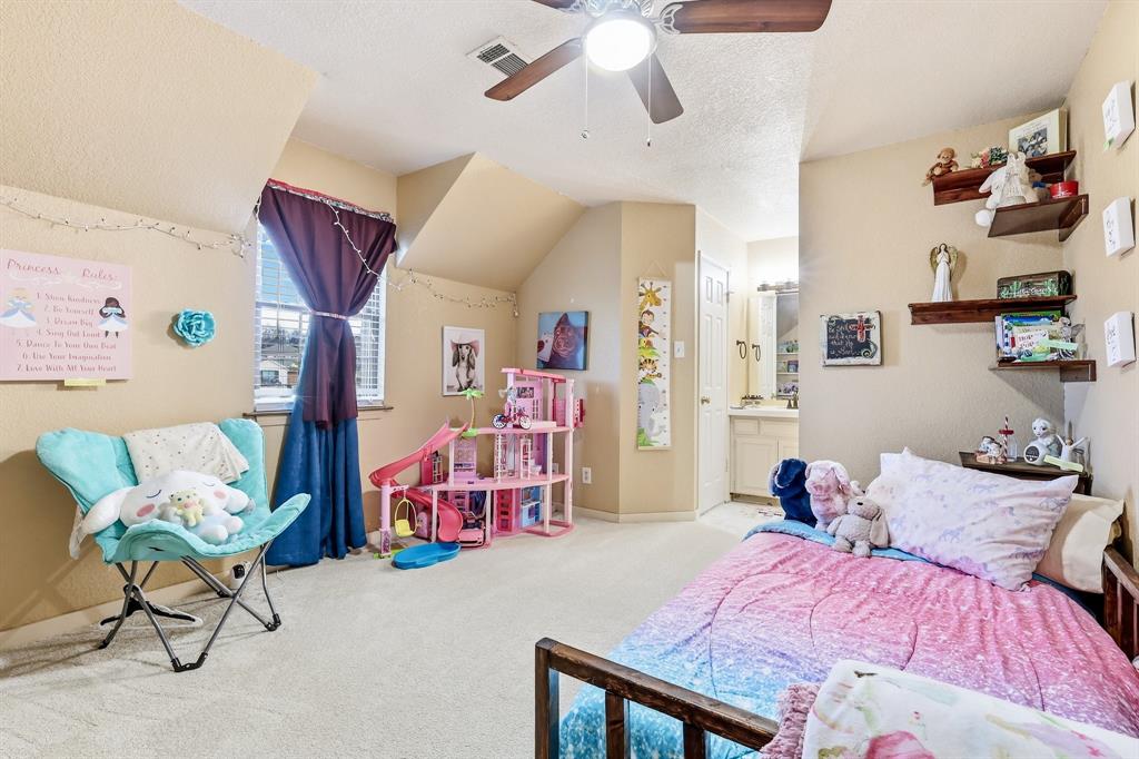 309 Sanders Road Denton, TX 76210 - Photo 20 of 40 a bedroom with a bed and a chandelier