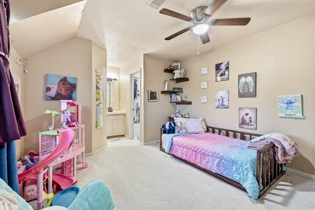 309 Sanders Road Denton, TX 76210 - Photo 21 of 40 a bedroom with a bed and a chandelier