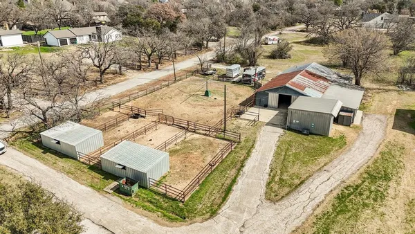 an aerial view of a house with a yard and trees