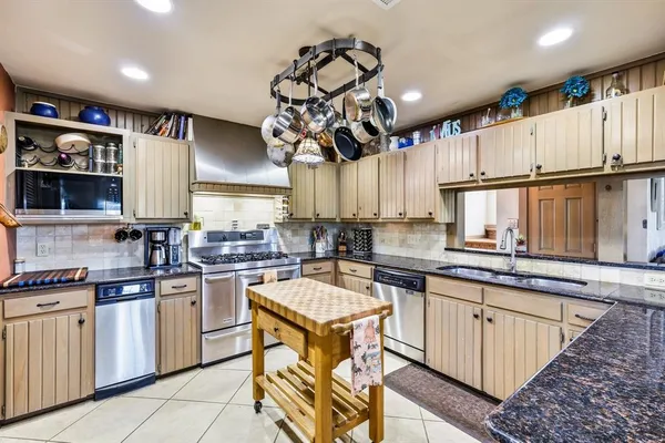 a kitchen with a sink counter top space appliances and cabinets