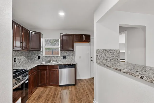 a kitchen with stainless steel appliances granite countertop a sink stove and microwave