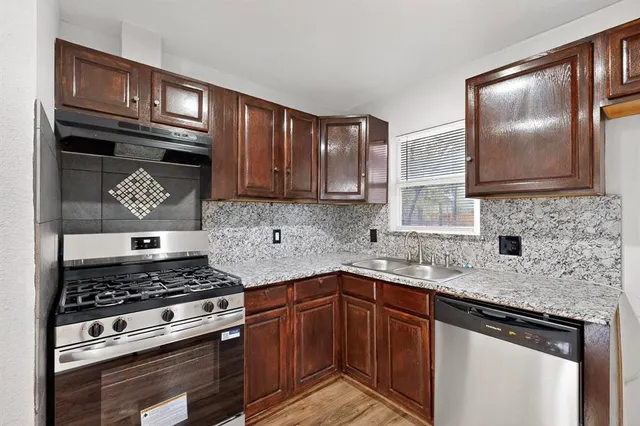 a kitchen with stainless steel appliances granite countertop a stove microwave and cabinets