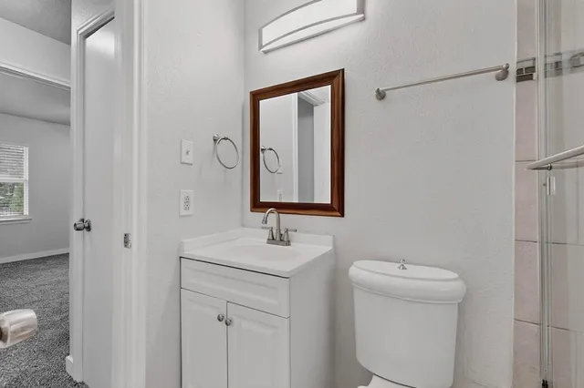 a bathroom with a toilet sink and mirror