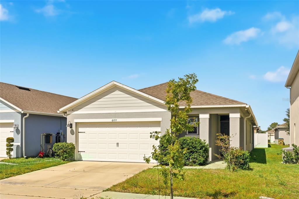 6777 Huntleigh Hammock Road Harmony, FL 34773 - Photo 2 of 32 a front view of a house with garden