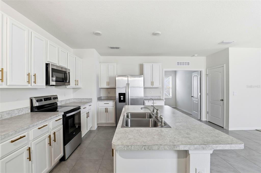 6777 Huntleigh Hammock Road Harmony, FL 34773 - Photo 6 of 32 a kitchen with a sink stove and refrigerator