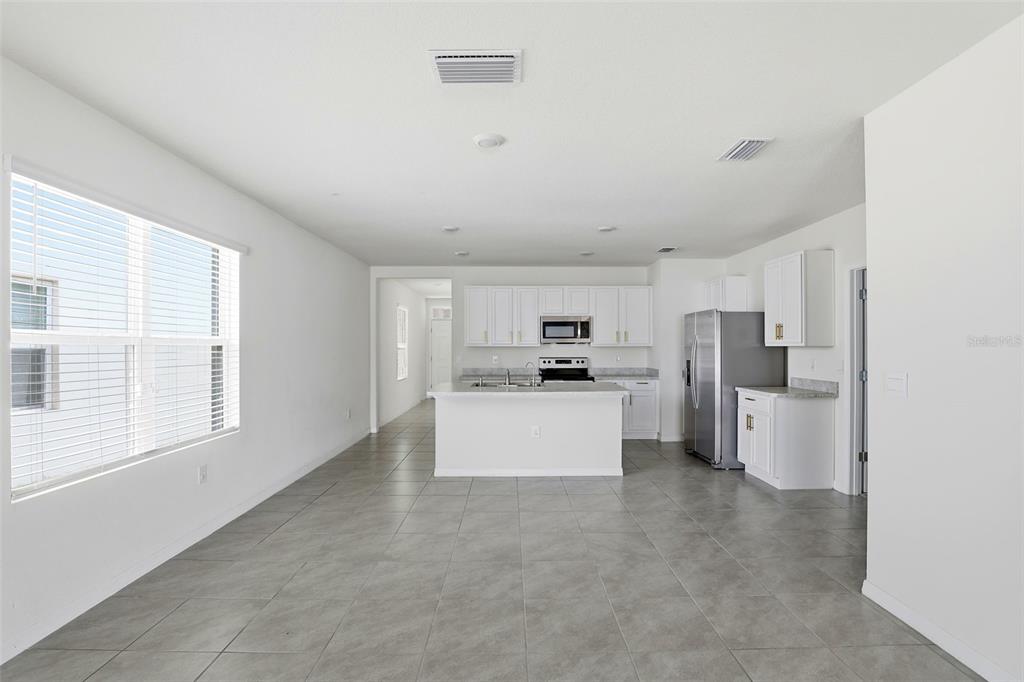 6777 Huntleigh Hammock Road Harmony, FL 34773 - Photo 9 of 32 a living room with stainless steel appliances kitchen island furniture and a window