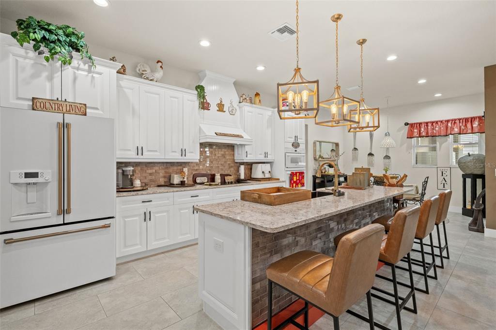 17601 Hanna Road Lutz, FL 33549 - Photo 16 of 48 a kitchen with stainless steel appliances kitchen island granite countertop a table chairs and a refrigerator