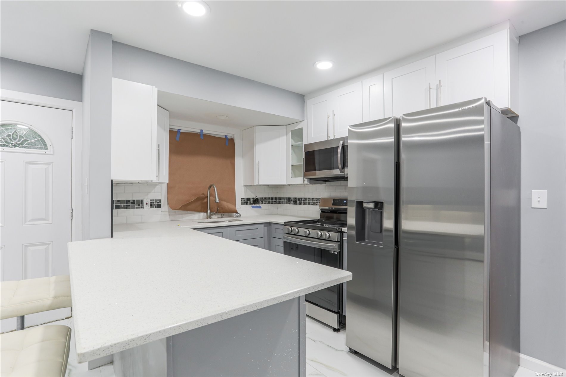 595 County Line Road Amityville, NY 11701 - Photo 1 of 1 a kitchen with a refrigerator a stove a sink and white cabinets