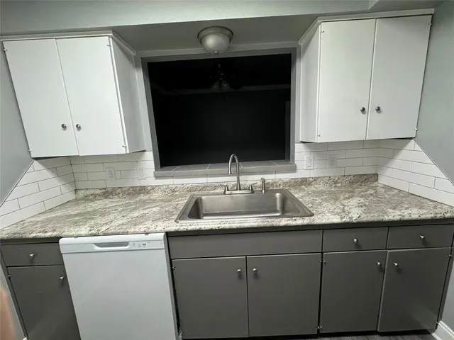 a kitchen with granite countertop a sink and a stove