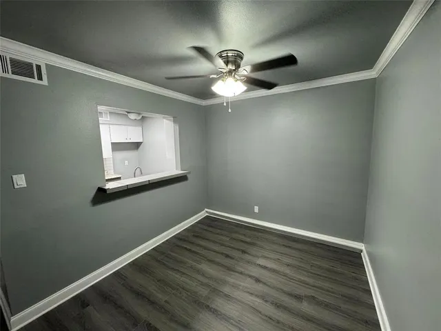 a view of a room with wooden floor and fan
